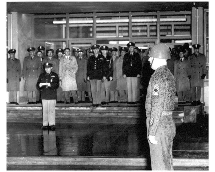 Photo of Army Ballistic Missile Agency activation ceremonty, with soldiers in formation and an officer in the background reading proclamation.