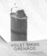Black and white photo of canister with label "violet smoke grenade"