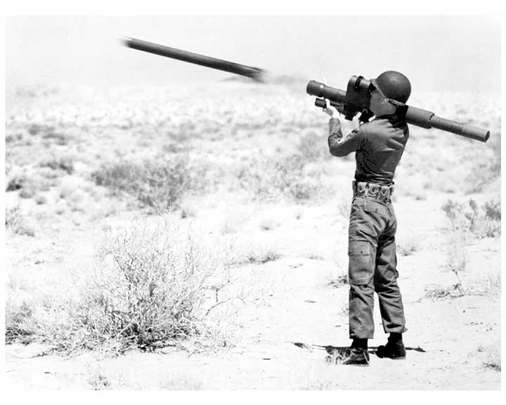 Photo of a soldier firing a REDEYE missile, with flight of missile captured in flight just as it leaves launch tube.