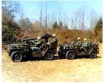 Photo of TOW missile mounted on a 1/4 ton JEEP, followed by another missile resupply 1/4 ton JEEP.