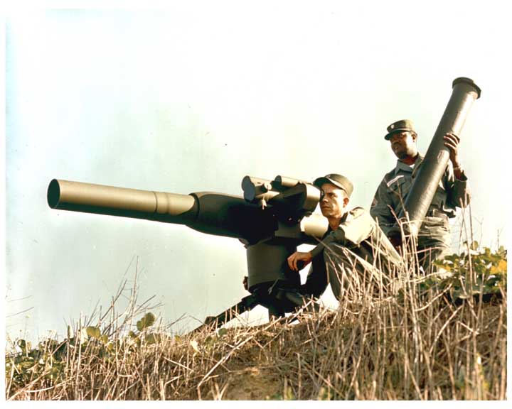 Photo of soldier sighting in a ground mounted TOW missile, with a staff sergeant behind him holding a missile.