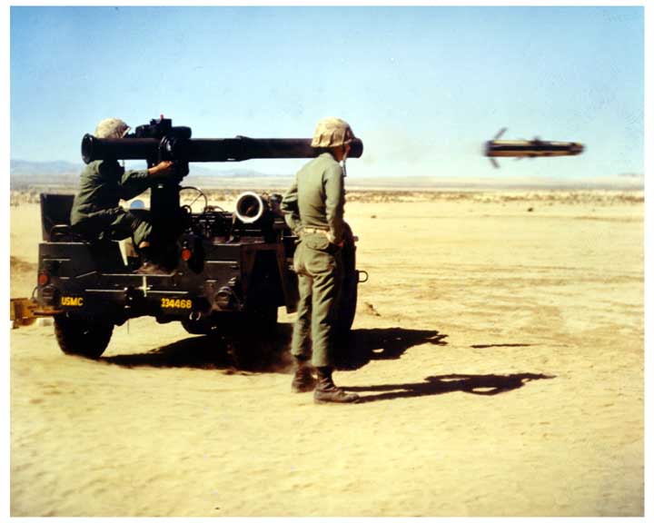 Photo of 2 marines firing a 1/4 ton JEEP mounted TOW missile, capturing the missile in flight.